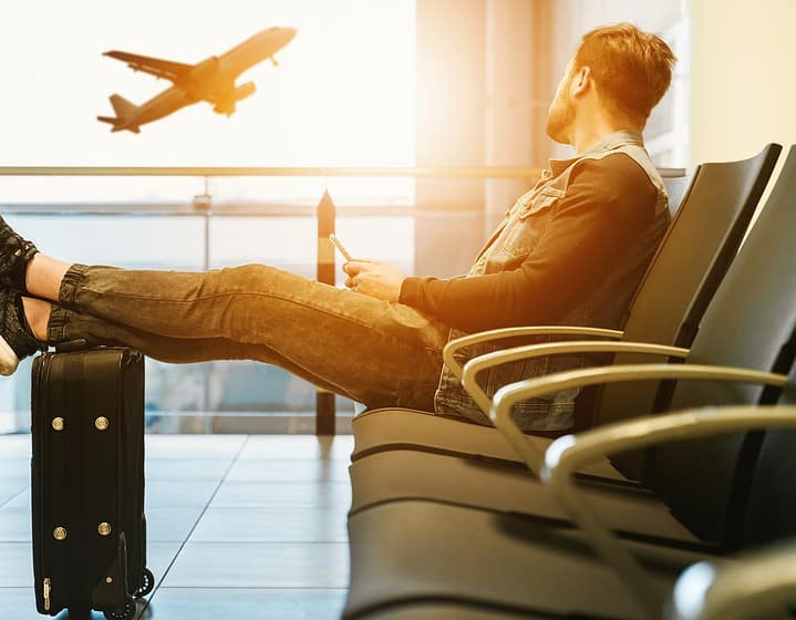 Man waiting on flight - Travel Insurance - Utopian Adventures